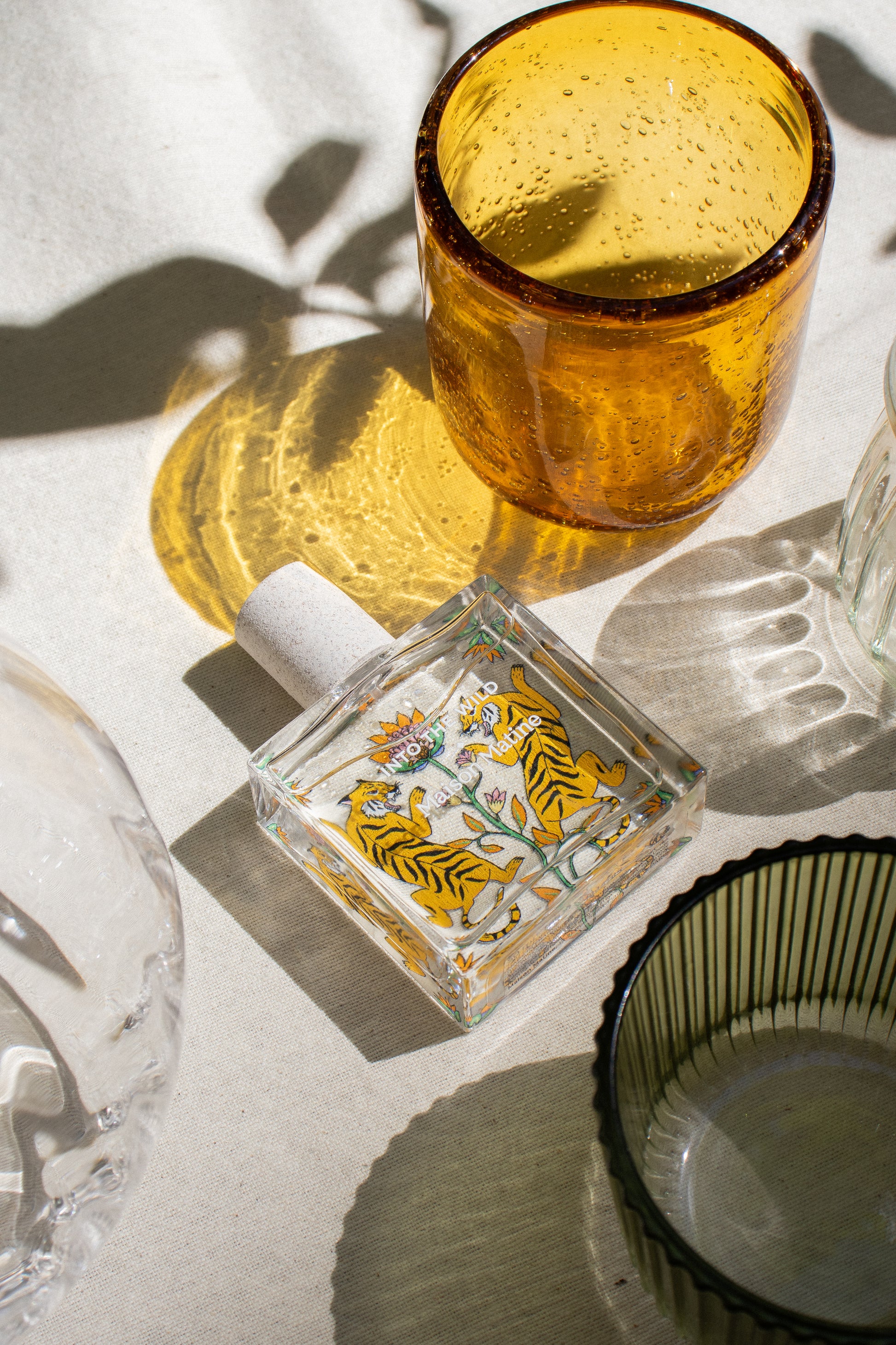 into the wild de Maison Matine, perfume nicho con ilustracion de tigres y flores en el bote cuadrado