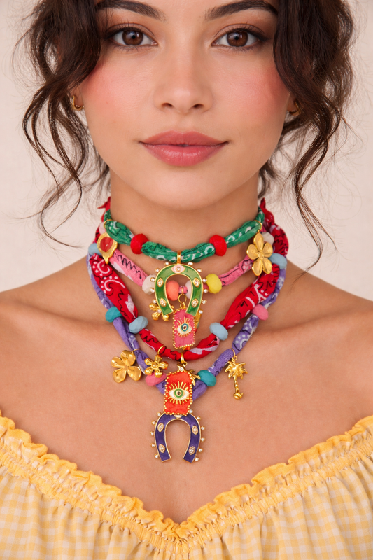 Woman wearing a colorful necklace with a plain background
