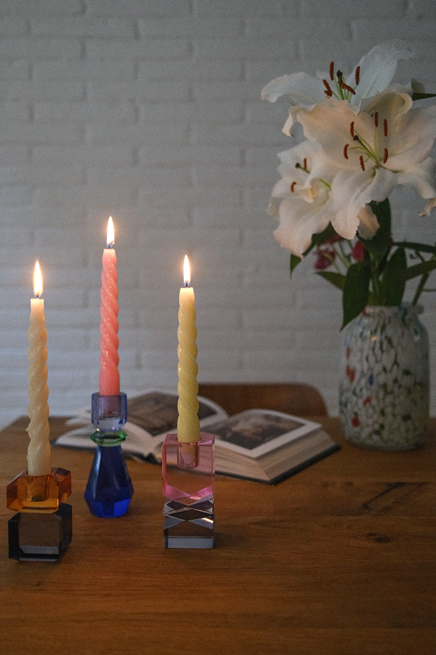 foto con Candelabros en cristales colorados con libro y jarron de flores