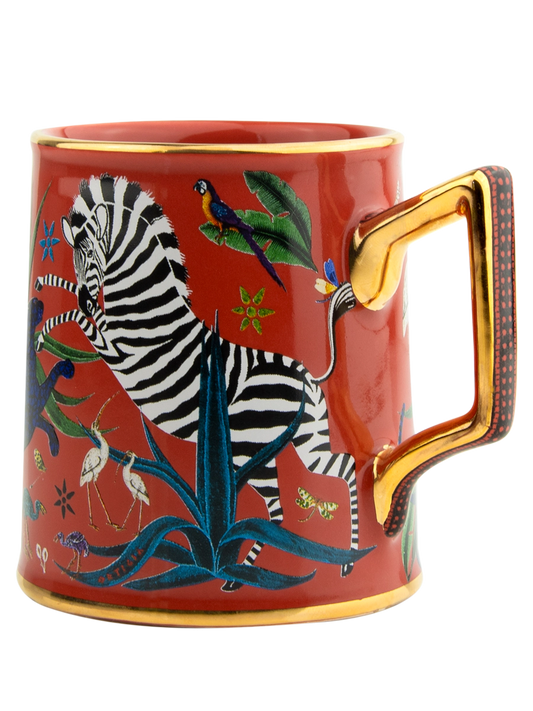 Taza roja con ilustraciones de animales y asa dorada, con la marca Ortigia.