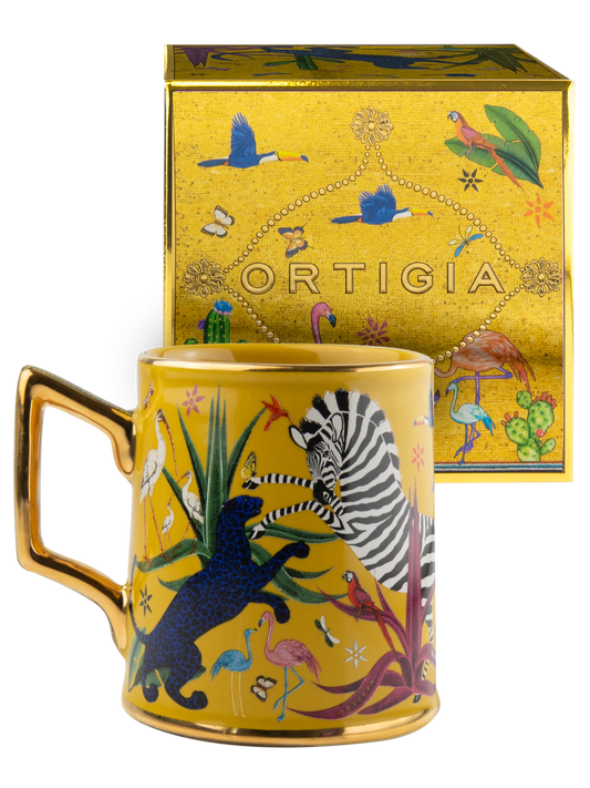 Taza amarilla con ilustraciones de animales y asa dorada, con la marca Ortigia y caja cuadrada decorada.