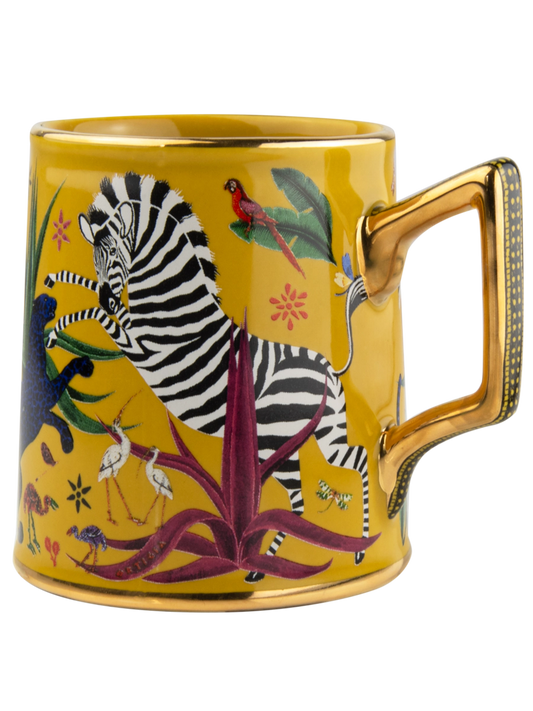 Taza amarilla con ilustraciones de animales y asa dorada, con la marca Ortigia y caja cuadrada decorada.
