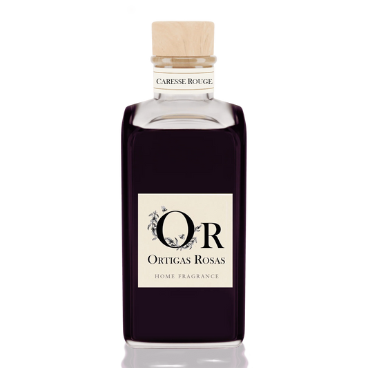 Caresse Rouge es una fragancia para hogar con notas de uva, fresa y cereza, se presenta en un envase de cristal con tapón de corcho y etiqueta color marfil