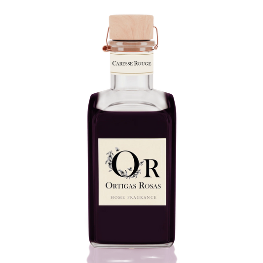 Caresse Rouge es una fragancia para hogar con notas de uva, fresa y cereza, se presenta en un envase de cristal con tapón de corcho y etiqueta color marfil