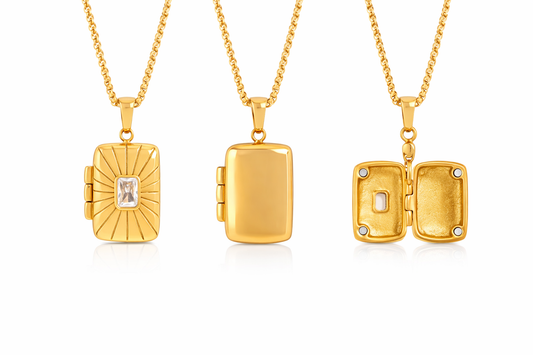 Three gold lockets with embedded stones on a white background