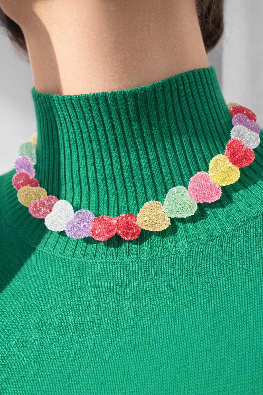 Green sweater with colorful candy heart-shaped beads around the neckline from Ortigas Rosas