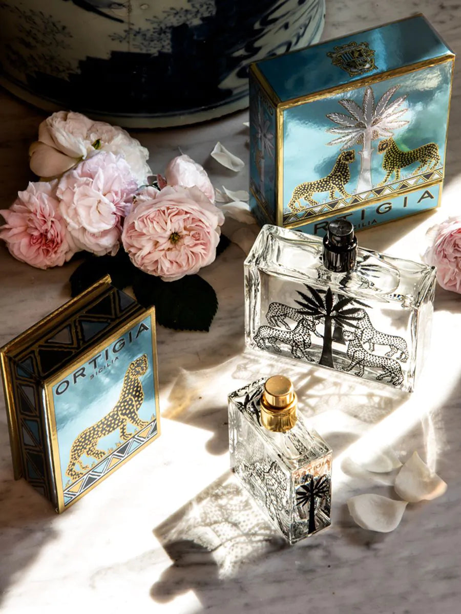foto romantica de perfume Florio de Ortigia con caja color turquesa y dorada con leopardo y flores
