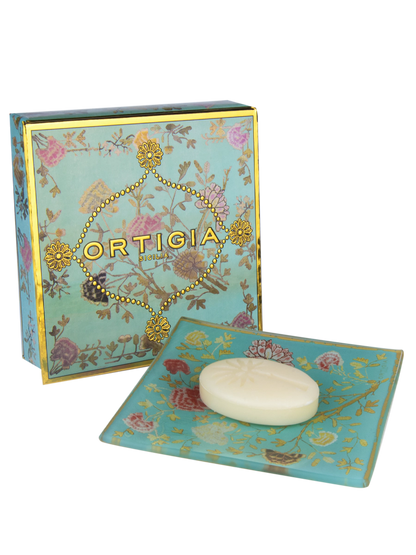 caja de ortigia decorada con flores y fondo color azul claro y plato de cristal azul claro con flores y jabon de 25g de Florio