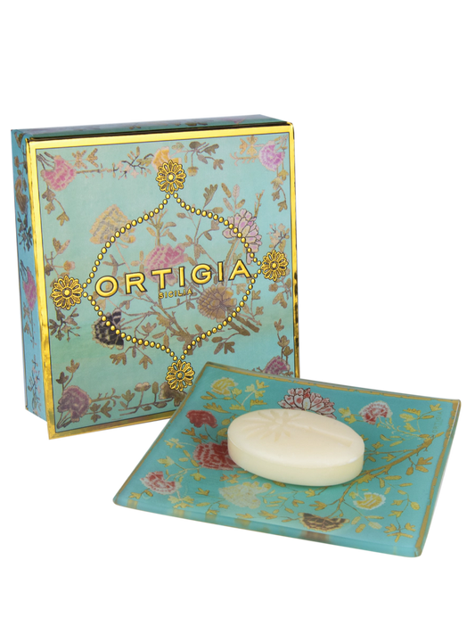 caja de ortigia decorada con flores y fondo color azul claro y plato de cristal azul claro con flores y jabon de 25g de Florio