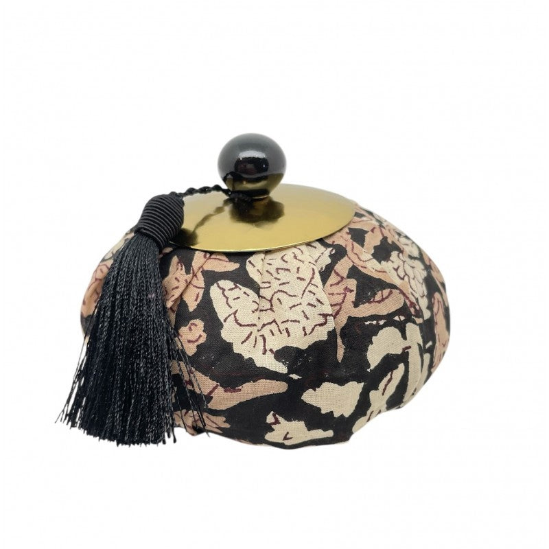 Decorative container with floral pattern and black tassel on a white background with perfume inside