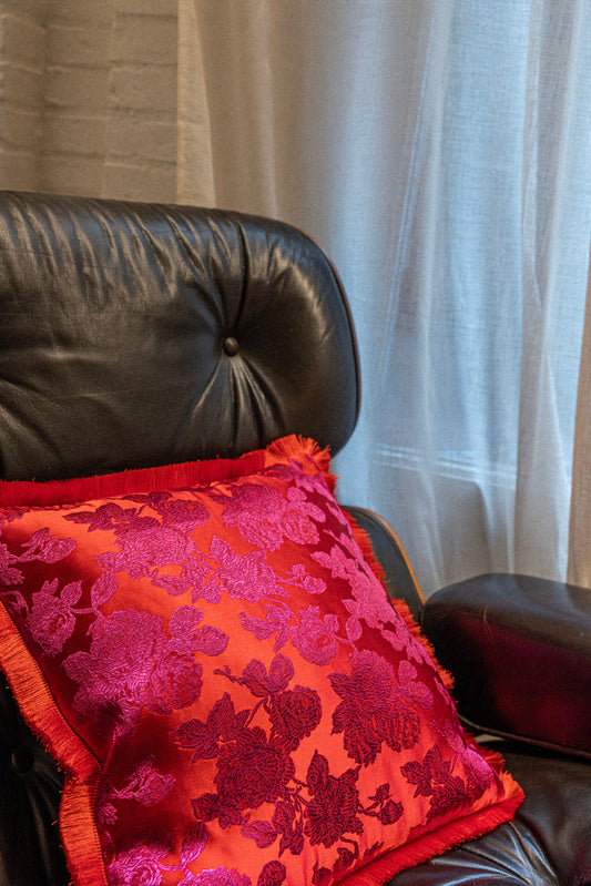 red satin cushion on a armchair vitra handmade with velvet back in pink color and with red frill