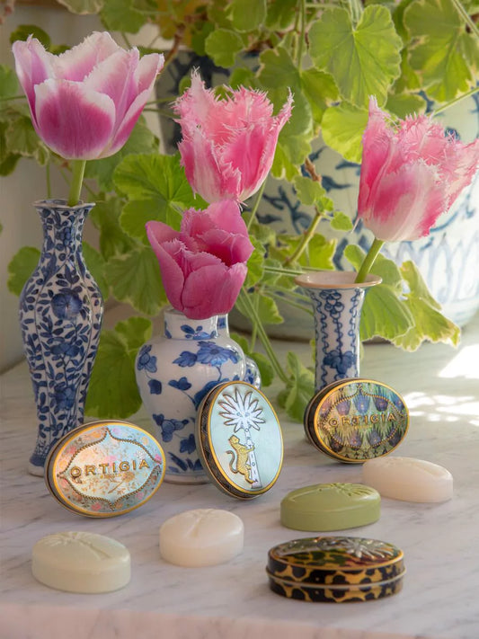 Decorative soaps with floral vases and tulips in the background