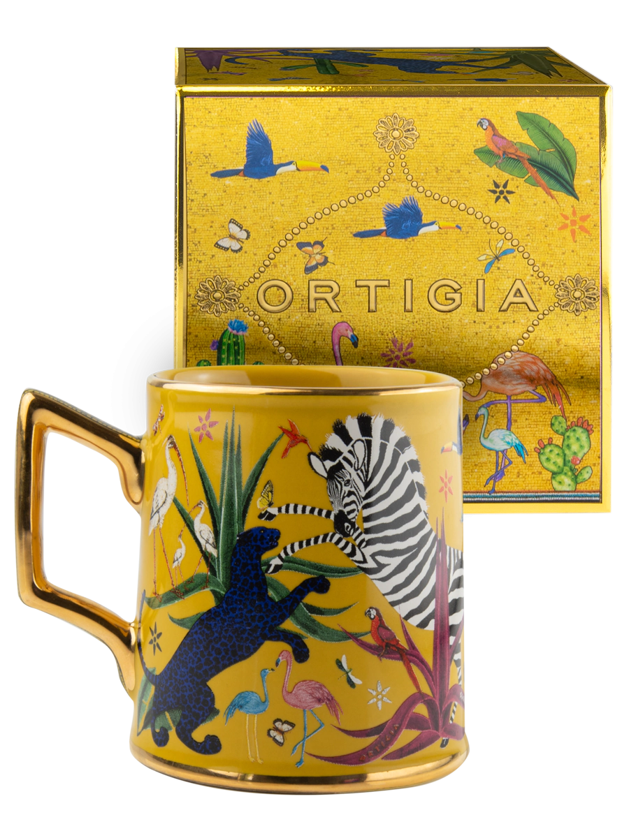 Taza amarilla con ilustraciones de animales y asa dorada, con la marca Ortigia y caja cuadrada decorada.