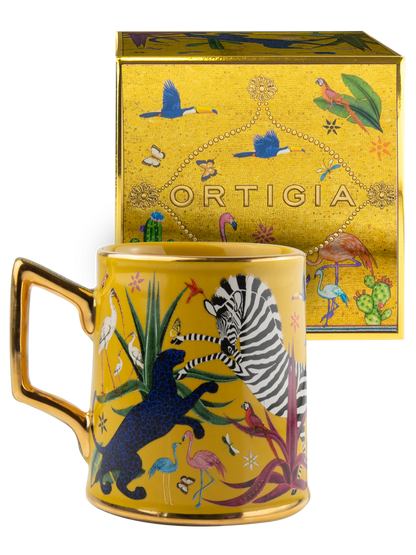 Taza amarilla con ilustraciones de animales y asa dorada, con la marca Ortigia y caja cuadrada decorada.