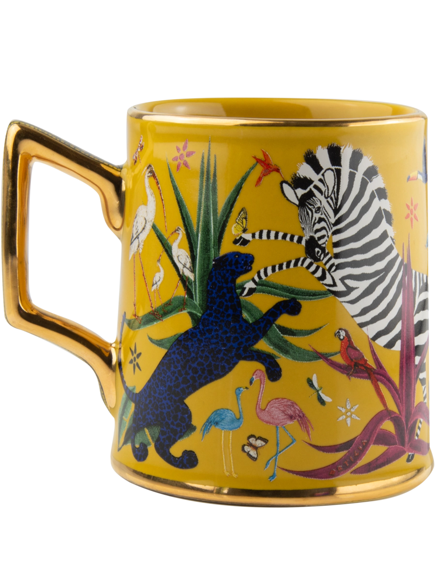 Taza amarilla con ilustraciones de animales y asa dorada, con la marca Ortigia y caja cuadrada decorada.