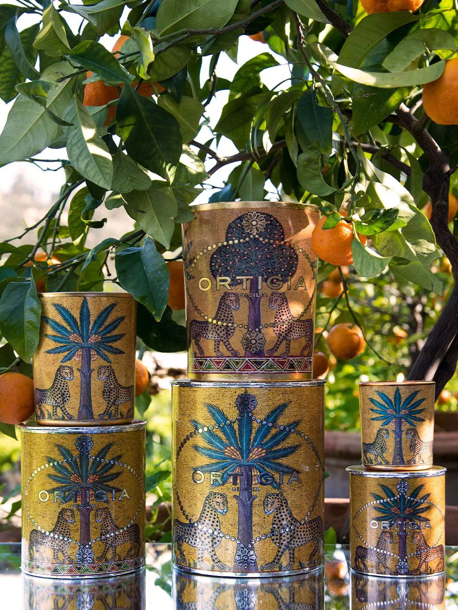 Zagara vela con envase decorado con palmera y leopardos y Ortigia en color plateado velas con arboles de naranjas